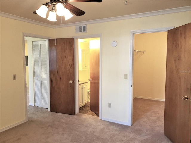 2360 SW Archer Rd Unit 404, Gainesville, FL 32608 - unfurnished bedroom with a closet, light colored carpet, a walk in closet, crown molding, and ensuite bathroom