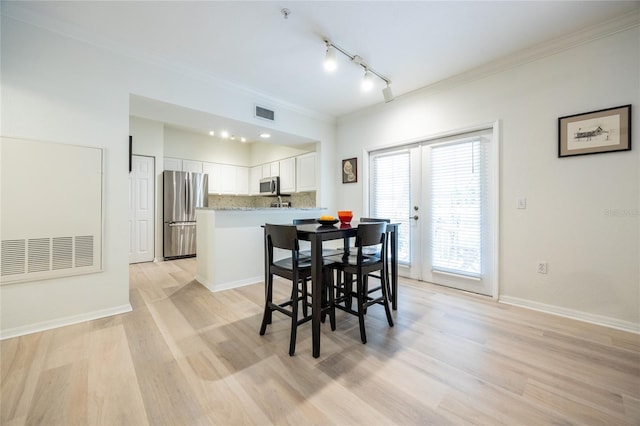 4850 SW 91st Ter Unit P201, Gainesville, FL 32608 - dining area with rail lighting, ornamental molding, light wood-type flooring, french doors, and baseboards