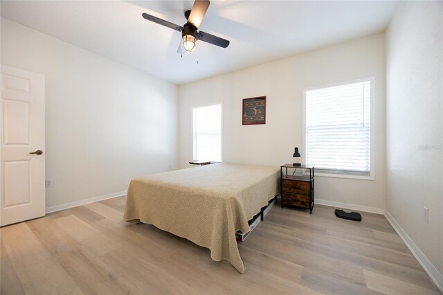 4850 SW 91st Ter Unit P201, Gainesville, FL 32608 - bedroom featuring light wood-style floors, baseboards, and ceiling fan
