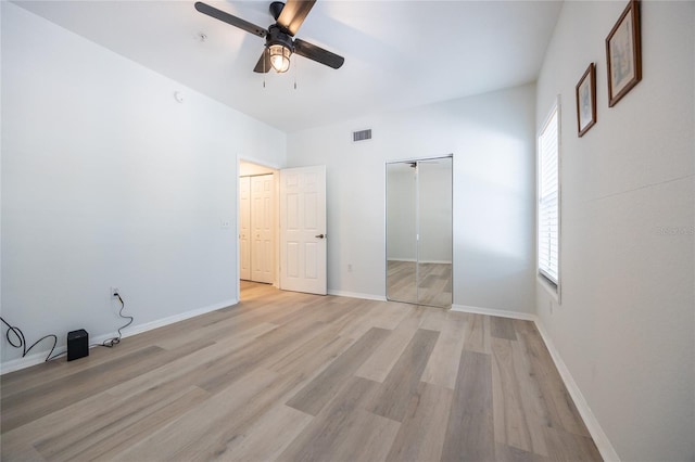 4850 SW 91st Ter Unit P201, Gainesville, FL 32608 - unfurnished bedroom featuring multiple windows, light wood-style floors, a closet, and baseboards