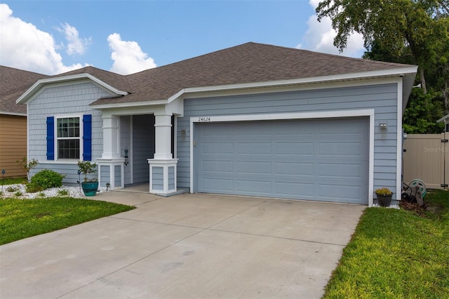 24624 NW 7th Ln, Newberry, FL 32669 - ranch-style home featuring driveway, a shingled roof, and an attached garage
