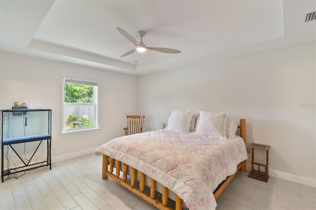 24624 NW 7th Ln, Newberry, FL 32669 - bedroom with a tray ceiling, baseboards, wood finished floors, and a ceiling fan