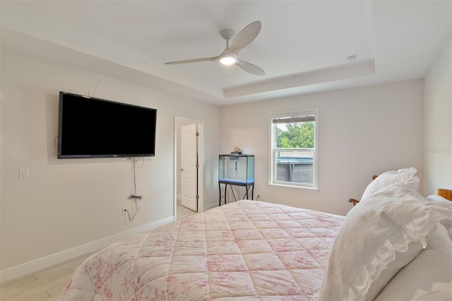 24624 NW 7th Ln, Newberry, FL 32669 - bedroom featuring a tray ceiling, baseboards, wood finished floors, and ceiling fan