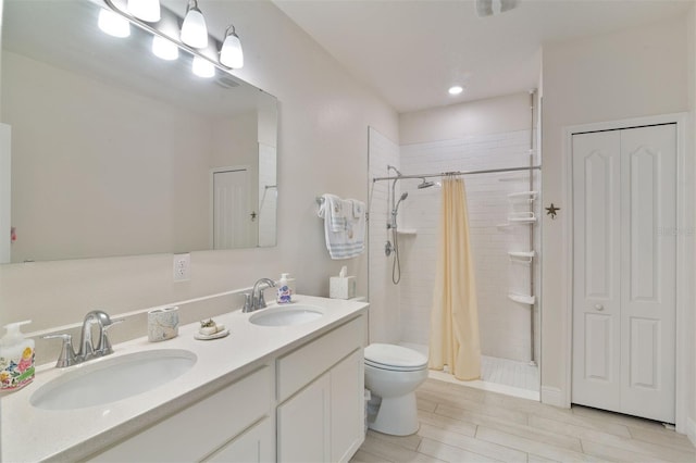 24624 NW 7th Ln, Newberry, FL 32669 - bathroom featuring a stall shower, toilet, double vanity, wood finished floors, and a closet