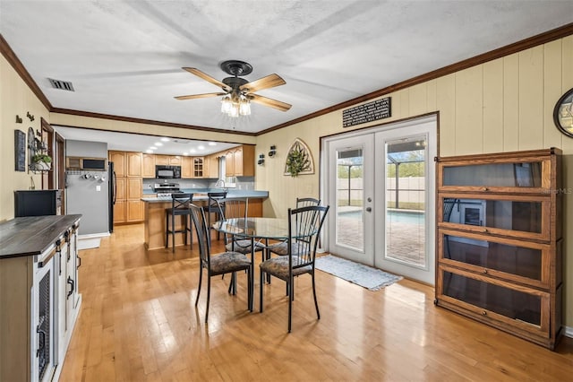 2204 Krista Ln, Brandon, FL 33511 - dining space featuring french doors, crown molding, light wood-style flooring, and a ceiling fan