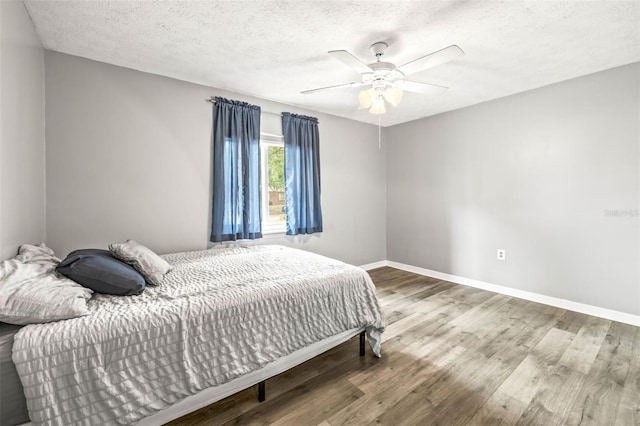 2204 Krista Ln, Brandon, FL 33511 - bedroom with wood finished floors, baseboards, a textured ceiling, and a ceiling fan