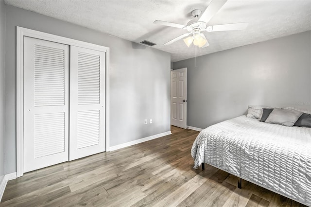 2204 Krista Ln, Brandon, FL 33511 - bedroom with a closet, wood finished floors, baseboards, a textured ceiling, and ceiling fan