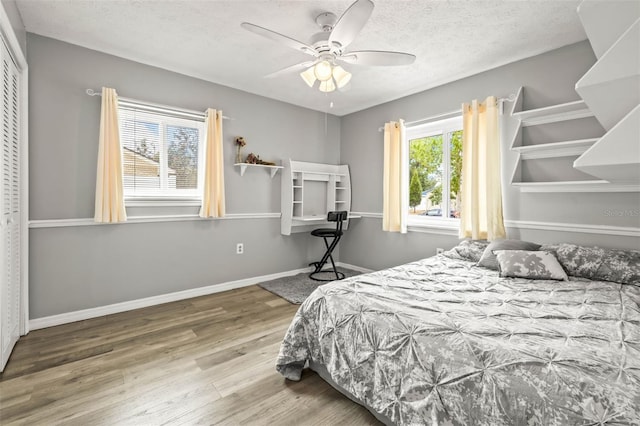 2204 Krista Ln, Brandon, FL 33511 - bedroom featuring wood finished floors, a textured ceiling, a ceiling fan, and baseboards