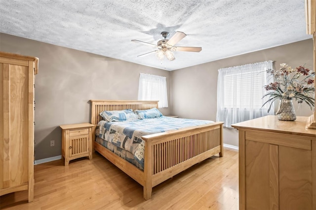 2204 Krista Ln, Brandon, FL 33511 - bedroom with light wood-style flooring, baseboards, a textured ceiling, and a ceiling fan