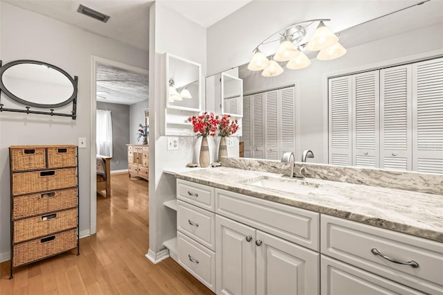 2204 Krista Ln, Brandon, FL 33511 - bathroom featuring wood finished floors, vanity, a chandelier, ensuite bathroom, and a closet