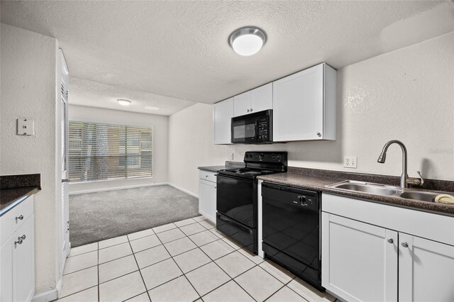 1810 NW 23rd Blvd Unit 203, Gainesville, FL 32605 - kitchen with black appliances, a sink, a textured ceiling, light carpet, and dark countertops