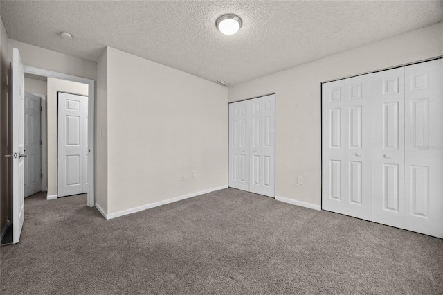 1810 NW 23rd Blvd Unit 203, Gainesville, FL 32605 - unfurnished bedroom featuring multiple closets, a textured ceiling, carpet, and baseboards