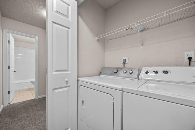1810 NW 23rd Blvd Unit 203, Gainesville, FL 32605 - laundry room featuring independent washer and dryer, light colored carpet, light tile patterned flooring, and baseboards