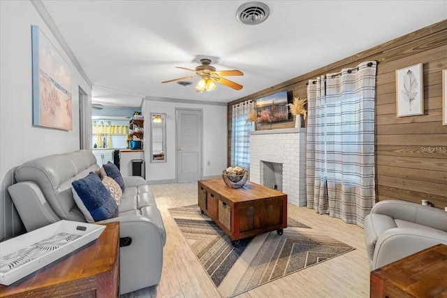 915 S Broadway Unit Ab, Englewood, FL 34223 - living area featuring wood walls, ceiling fan, light wood finished floors, and a fireplace