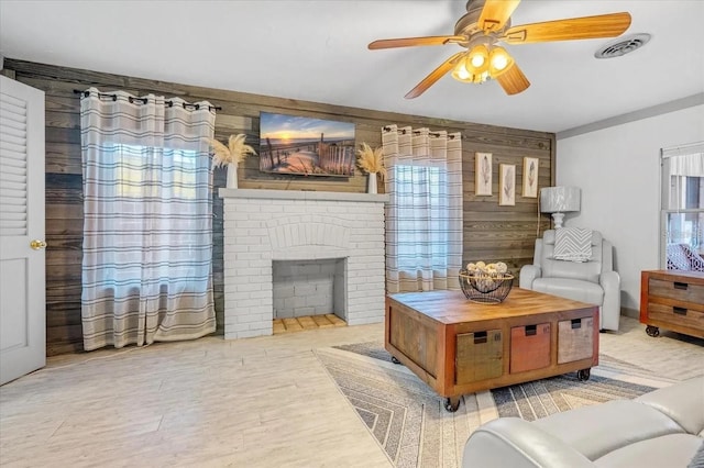 915 S Broadway Unit Ab, Englewood, FL 34223 - living area featuring wooden walls, ceiling fan, plenty of natural light, wood finished floors, and a brick fireplace