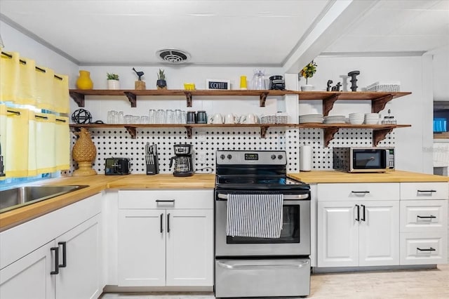 915 S Broadway Unit Ab, Englewood, FL 34223 - kitchen featuring appliances with stainless steel finishes, open shelves, butcher block countertops, and white cabinets