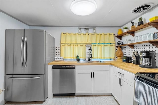 915 S Broadway Unit Ab, Englewood, FL 34223 - kitchen with appliances with stainless steel finishes, butcher block counters, a sink, open shelves, and white cabinets