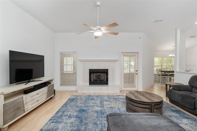 6806 NW 105th Ave, Alachua, FL 32615 - living room featuring a ceiling fan, light wood finished floors, a fireplace, and a chandelier