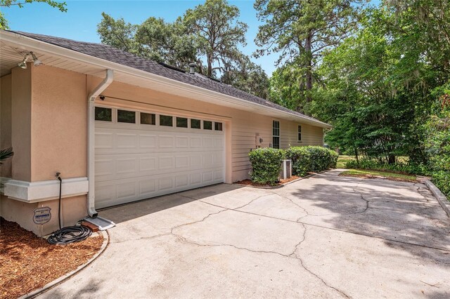 6806 NW 105th Ave, Alachua, FL 32615 - view of home's exterior featuring driveway, stucco siding, a garage, and a shingled roof