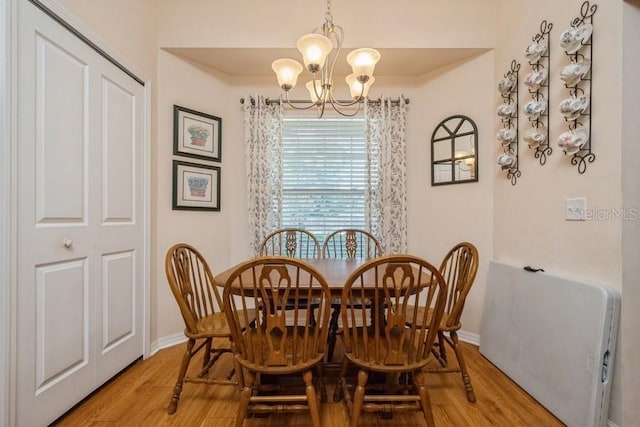 15628 NW 137th Way, Alachua, FL 32615 - dining room with a chandelier, wood finished floors, and baseboards