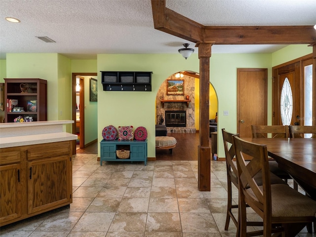 113 Myrtlewood Point Rd, East Palatka, FL 32131 - dining space with a textured ceiling, baseboards, a fireplace, and arched walkways