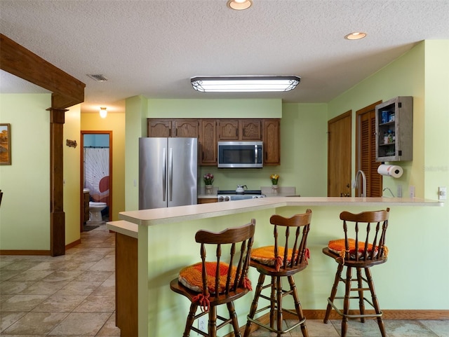 113 Myrtlewood Point Rd, East Palatka, FL 32131 - kitchen featuring stainless steel appliances, a peninsula, light countertops, baseboards, and a textured ceiling