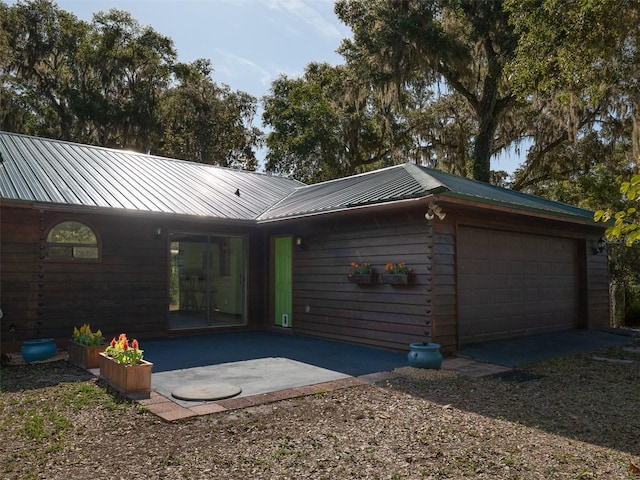 113 Myrtlewood Point Rd, East Palatka, FL 32131 - view of front of property with metal roof, an attached garage, and a patio area