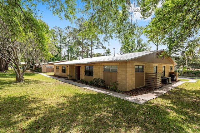 915 NW 40th Ave, Gainesville, Fl, FL 32605 - back of property with a yard, metal roof, and central AC