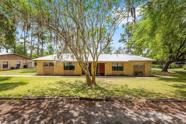 915 NW 40th Ave, Gainesville, Fl, FL 32605 - view of front facade with a front yard, metal roof, and concrete block siding