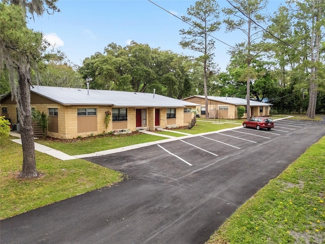 915 NW 40th Ave, Gainesville, Fl, FL 32605 - view of front facade with concrete block siding, uncovered parking, and a front yard