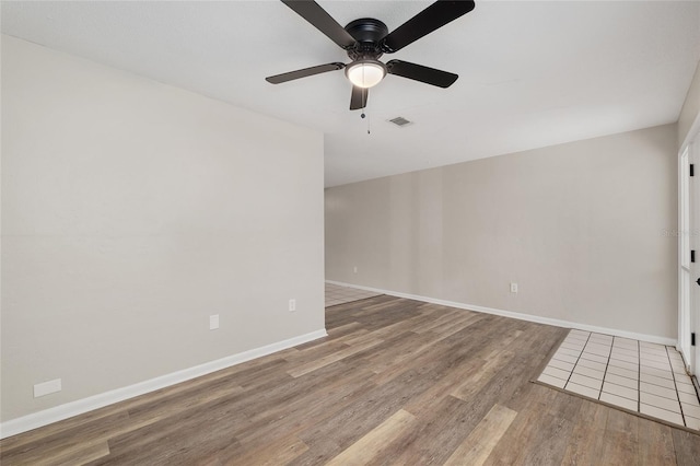 915 NW 40th Ave, Gainesville, Fl, FL 32605 - empty room with wood finished floors, a ceiling fan, and baseboards