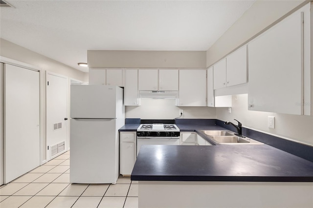 915 NW 40th Ave, Gainesville, Fl, FL 32605 - kitchen with white appliances, under cabinet range hood, dark countertops, white cabinets, and a peninsula