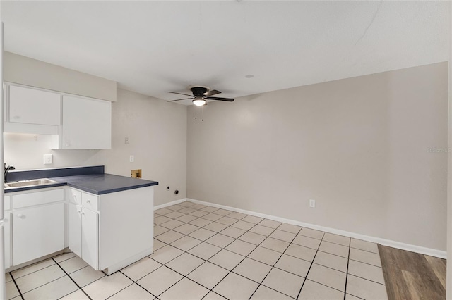 915 NW 40th Ave, Gainesville, Fl, FL 32605 - kitchen featuring a sink, dark countertops, ceiling fan, white cabinets, and a peninsula