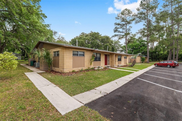 915 NW 40th Ave, Gainesville, Fl, FL 32605 - ranch-style house with a front lawn, cooling unit, uncovered parking, and concrete block siding