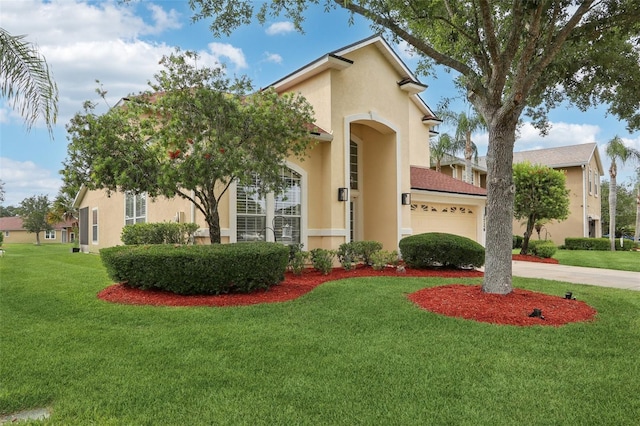 1726 Chatham Village Dr, Fleming Island, FL 32003 - mediterranean / spanish-style home featuring stucco siding, an attached garage, a front yard, and concrete driveway