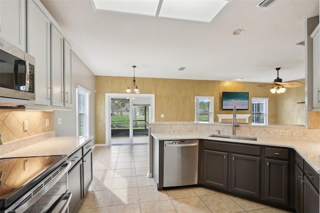 1726 Chatham Village Dr, Fleming Island, FL 32003 - kitchen with stainless steel appliances, a sink, backsplash, a peninsula, and decorative light fixtures
