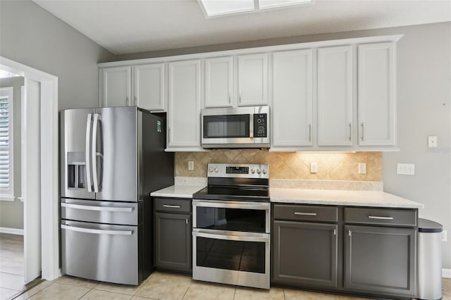 1726 Chatham Village Dr, Fleming Island, FL 32003 - kitchen with appliances with stainless steel finishes, tasteful backsplash, white cabinets, and light tile patterned flooring