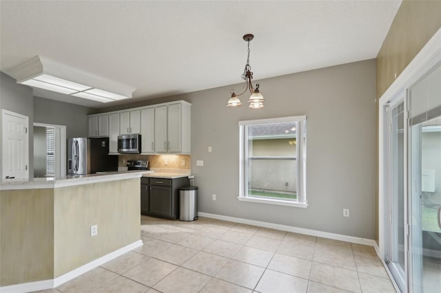 1726 Chatham Village Dr, Fleming Island, FL 32003 - kitchen featuring appliances with stainless steel finishes, light countertops, light tile patterned flooring, decorative light fixtures, and backsplash