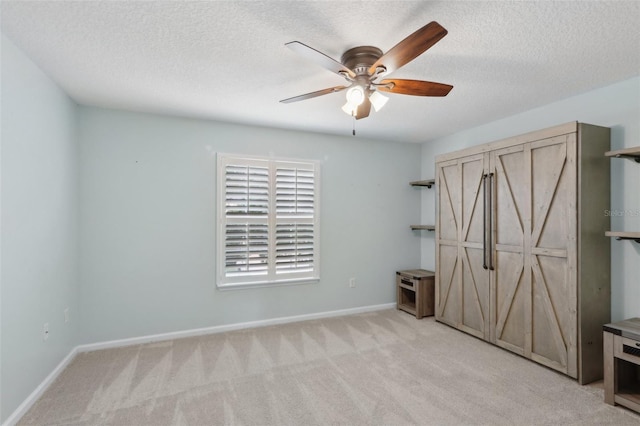 1726 Chatham Village Dr, Fleming Island, FL 32003 - unfurnished bedroom featuring light colored carpet, baseboards, a textured ceiling, and a ceiling fan