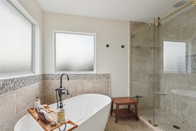 1726 Chatham Village Dr, Fleming Island, FL 32003 - bathroom featuring a stall shower, a soaking tub, tile walls, and tile patterned flooring
