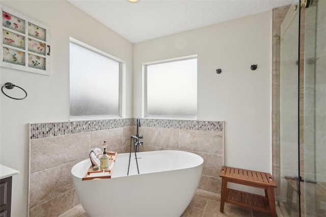 1726 Chatham Village Dr, Fleming Island, FL 32003 - full bath with tile walls, a freestanding bath, a stall shower, vanity, and a wainscoted wall