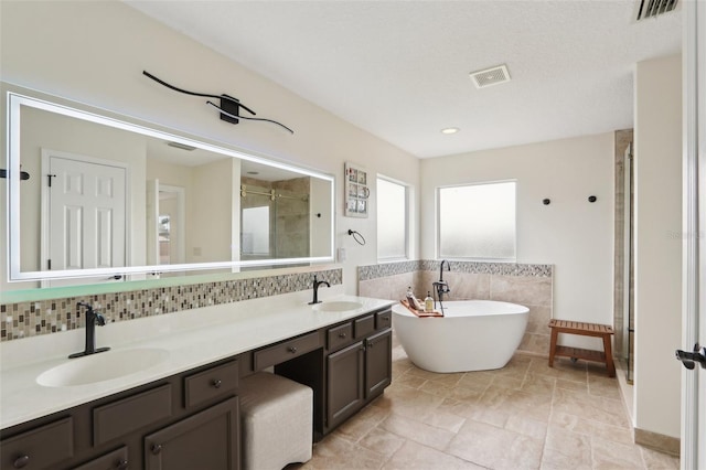 1726 Chatham Village Dr, Fleming Island, FL 32003 - bathroom with a stall shower, tile walls, a freestanding bath, double vanity, and backsplash