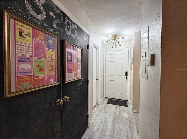 4000 SW 23rd St Unit 3-205, Gainesville, FL 32608 - doorway with a textured ceiling, light wood-style floors, and baseboards