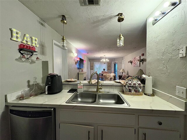 4000 SW 23rd St Unit 3-205, Gainesville, FL 32608 - kitchen with dishwasher, a sink, a textured ceiling, a chandelier, and decorative light fixtures