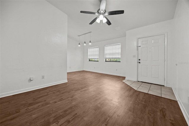 6912 SW 45th Ave, Gainesville, FL 32608 - unfurnished living room with wood finished floors, baseboards, ceiling fan, and vaulted ceiling