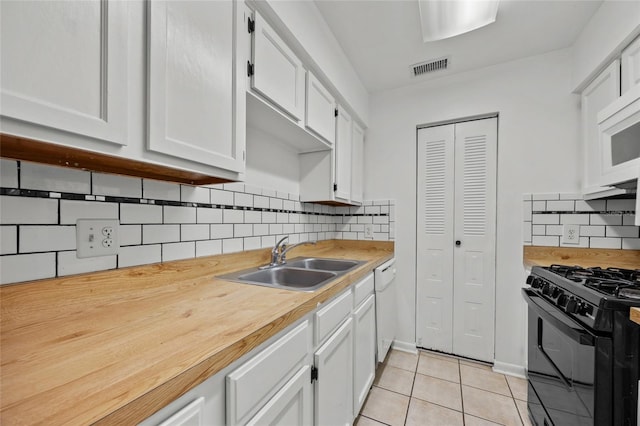 6912 SW 45th Ave, Gainesville, FL 32608 - kitchen featuring a sink, black gas range oven, light tile patterned floors, white cabinets, and decorative backsplash