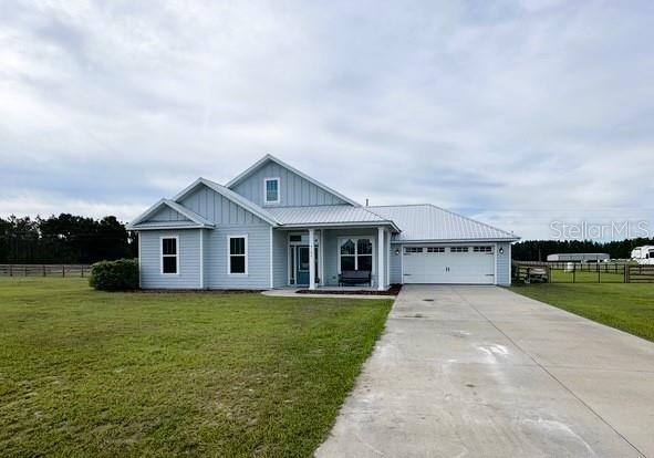 6180 SW 83rd Pl, Trenton, FL 32693 - view of front of home featuring driveway, board and batten siding, covered porch, and a garage