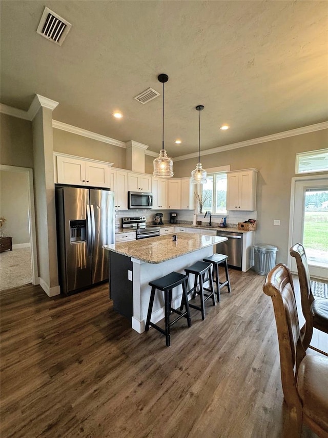 6180 SW 83rd Pl, Trenton, FL 32693 - kitchen with stainless steel appliances, a center island, white cabinets, plenty of natural light, and recessed lighting