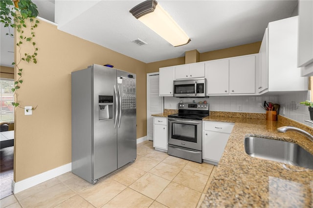 680 NW 67th Pl, Ocala, FL 34475 - kitchen with stainless steel appliances, a sink, white cabinetry, and baseboards