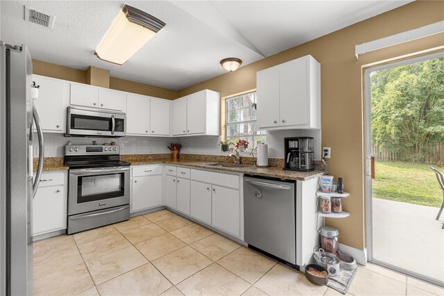 680 NW 67th Pl, Ocala, FL 34475 - kitchen featuring appliances with stainless steel finishes, a sink, plenty of natural light, and white cabinetry